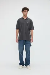 Remera polo manga corta color blanco, confeccionada en tela piqué de algodón lavado con textura extra suave. Cuenta con media cartera de botones, cuello y puños acanalados con diseño de líneas a contratono, y bordado sutil de la marca en el pecho. Calce clásico.