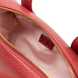 Cartera tipo baúl de diseño cilíndrico, confeccionada en material sintético con textura graneada. Presenta el logotipo de la marca XL Extra Large grabado en relieve en el frente, doble asa fija superior y una correa bandolera regulable y extraíble. Cuenta con cierre superior y herrajes metálicos dorados.