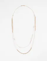 Collar largo doble con cadena dorada y detalles de perlas.