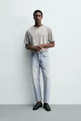 Jeans regular fit de denim de algodón en color gris con efecto lavado, tiro medio, diseño de cinco bolsillos y cierre frontal con botones.