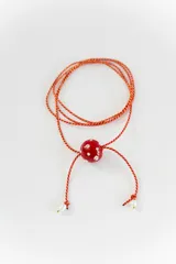 Gargantilla tipo bolo tie de tiento trenzado verde con dije esférico celeste con brillos incrustados.