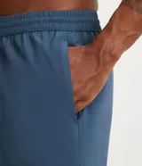 Bermuda deportiva masculina con cintura elástica y cordón de ajuste. Presenta bolsillos laterales y aberturas en el bajo para mayor movilidad.