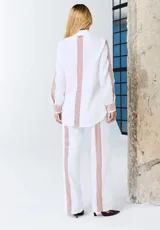 Pantalón blanco de corte recto con franjas laterales a rayas rojas, bolsillos laterales y cintura elastizada.