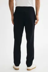 Jogger de vestir slim fit color azul marino, con pliegues adelante y atrás, elástico revestido con cordón ajustable en la cintura y bolsillos al bies.