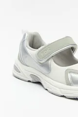 Zapatillas deportivas negras con suela blanca de 4cm de alto y tira ajustable con velcro.