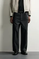 Pantalón relaxed fit negro confeccionado en tejido de algodón con estructura diagonal, estilo de cinco bolsillos y cierre frontal con cremallera y botón metálico.