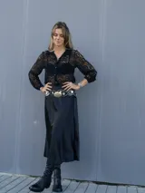 Falda midi evasé de raso color negro, con cintura elástica y cinturón con apliques metálicos.