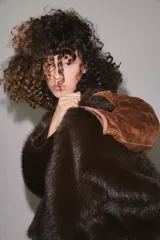 Bolso de hombro formato mini shopper confeccionado en piel, con diseño fruncido, doble asa de mano con pespuntes decorativos y cierre mediante clip metálico.