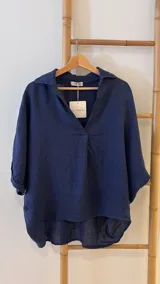 Blusa azul marino de lino, con cuello camisero que forma un escote en V, mangas cortas dobladas y calce holgado.