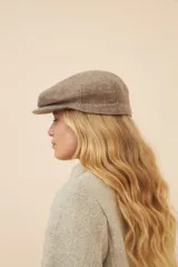 Boina con visera de lana fina uruguaya natural, sin teñir, con diseño de tejido texturizado en tonos beige y marrón.