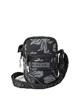 Bandolera Rip Curl de color negro con estampado floral gris, compartimento principal con cierre, bolsillo frontal con cierre y correa ajustable con el nombre de la marca.