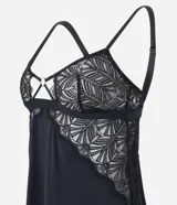 Camisón corto de color negro, confeccionado en tul con detalles de encaje floral en el busto y laterales. Presenta tirantes finos regulables, escote en V con detalle metálico central y un corte fluido con abertura lateral.