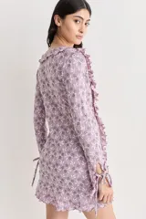 Vestido corto de encaje color lila con estampado floral, escote en V y volados.