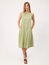 Vestido midi sin mangas de corte recto y holgado, color beige, con cuello redondo y bolsillos laterales.