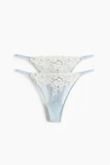 Pack de dos bombachas colaless de malla color celeste con detalles de encaje floral en tono crudo, tiro bajo y laterales finos.