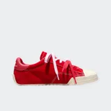 Championes Converse modelo Chuck Taylor Lo Pro, confeccionados en gamuza premium de color rojo con detalles en cuero al tono en el talón. Presentan puntera de goma reforzada, cordones en contraste y suela de goma con diseño texturizado.