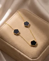 Collar de acero con baño de oro, con cadena eslabonada y tres dijes en forma de trébol u onix negro con borde dorado.