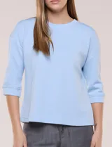 Buzo de calce relajado color negro, confeccionado en modal con cuello redondo clásico, mangas tres cuartos de hombros caídos con puño y ruedo recto.