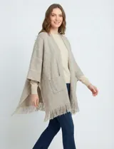 Cardigan tipo kimono de tejido suave, color negro y blanco con patrón de espiga (herringbone). Presenta bolsillos delanteros y terminación con flecos en el ruedo.