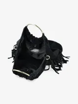 Cartera de mano confeccionada en cuero gamuzado color marrón, con diseño flexible y detalles de flecos laterales. Presenta un asa rígida metálica circular y una abertura superior fruncida.