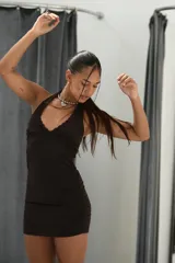 Vestido corto marrón oscuro, ajustado al cuerpo, con escote halter y detalle de encaje en el borde del busto.