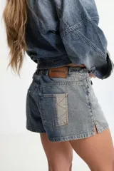 Short de jean azul con cintura elástica y cordón blanco con letras rojas.