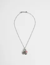 Collar de cadena fina plateada con un conjunto de dijes colgantes, incluyendo un sol, una luna y elementos decorativos con detalles en color rosado.