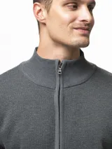 Campera tejida de punto con cierre frontal completo, cuello medio y dos bolsillos laterales abiertos. Presenta un diseño de textura en relieve y puños acanalados.