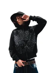 Hoodie con cierre frontal, color negro, con estampado gráfico de hojas de acanto en color blanco que recorre el frente y las mangas. Cuenta con bolsillos laterales y cierre metálico.