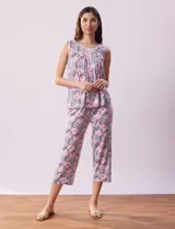 Conjunto de pijama marca René Rofé, compuesto por remera de mangas cortas con escote en V abotonado y pantalón capri con cintura elastizada. Diseño estampado con flores azules sobre fondo blanco.