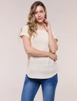Blusa celeste de tejido calado tipo pointelle, con escote redondo, mangas cortas con dobladillo y presilla con botón, y ruedo curvo.