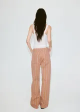 Jeans de corte recto y tiro medio con diseño de rayas verticales en tonos marrón y blanco.