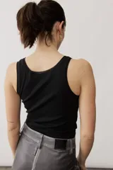 Musculosa de tejido rib color beige con detalles marrones en los bordes del cuello y sisas. Cuenta con el logotipo de la marca bordado en el pecho.