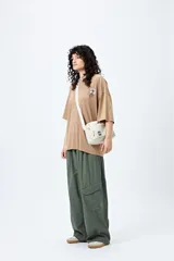 Remera negra de corte holgado con mangas cortas amplias y cuello redondo. Estampado pequeño de flor en el pecho y estampado grande en la espalda con diseño floral y texto.