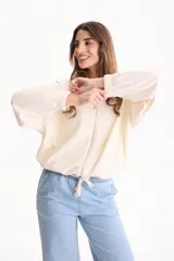 Campera deportiva negra de corte bomber sin friza, con cierre frontal completo, capucha y elásticos ajustables en la cintura.