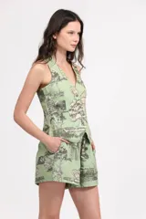 Chaleco verde con estampado de paisaje, escote en V y cierre con botones.