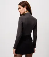 Body de manga larga con cuello alto y detalle de fruncido central en el frente. Confeccionado en tejido seamless ajustado al cuerpo.