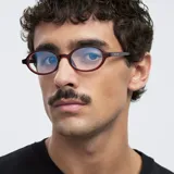 Lentes blueblocker con armazón ovalado de color bordó translúcido y protección para pantallas.