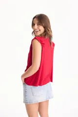 Blusa de viscosa negra sin mangas, con diseño fluido, cuello redondo y detalles de tablas verticales en el pecho con terminaciones de encaje en las sisas.