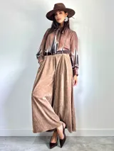 Pantalón tipo palazzo de corte oversized, confeccionado en tela con textura aterciopelada en color negro. Presenta cintura alta con pinzas, bolsillos laterales y un cinturón ancho integrado con hebilla al tono.