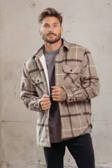 Sobrecamisa de corte holgado con diseño a cuadros en tonos azul marino y marrón, confeccionada con forro interior de corderito sintético, cuello clásico, cierre frontal de botones y bolsillos en el pecho.