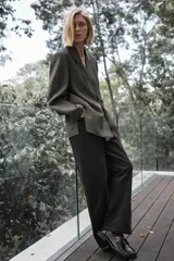 Blazer oversize de Zara confeccionado en hilatura con lana, con diseño de cuadros en tonos grises y líneas finas rojizas. Presenta cuello con solapa de muesca, cierre frontal cruzado con un botón, bolsillos de vivo en el delantero y forro interior.