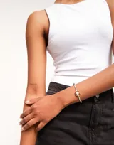 Pulsera de hilo color verde agua con dije central de perla blanca engarzada en fornitura dorada bañada en oro de 18k. Ajustable con nudo corredizo.