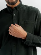 Camisa de manga larga confeccionada en pana de algodón, con cuello clásico, cierre frontal de botones y bolsillo en el pecho.