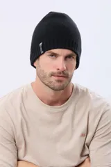 Gorro tejido de punto reversible en dos colores, azul marino y negro, con etiqueta lateral de la marca.