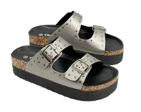Sandalias negras de plataforma con dos tiras ajustables con hebillas metálicas y tachas decorativas, entresuela estilo corcho y suela de goma.
