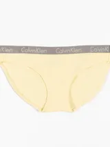Bombacha clásica color amarillo pálido de algodón elástico, con cintura de tiro medio y banda elástica gris con el logo de Calvin Klein.
