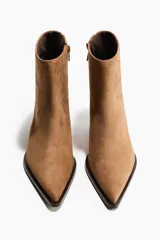 Botines de gamuza color marrón con punta fina y taco kitten. Presentan un diseño minimalista con cierre lateral y forro interior de satén.