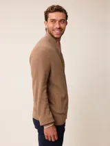 Cardigan de punto gris con cierre frontal completo, cuello tipo mao y puños acanalados. Presenta un pequeño logo bordado en el pecho y detalles en contraste en el interior del cuello y puños.