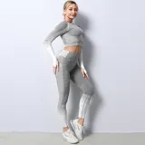 Remera deportiva de manga larga con diseño seamless, cuello redondo y efecto degradado de gris a blanco. Presenta aberturas para los pulgares en los puños.